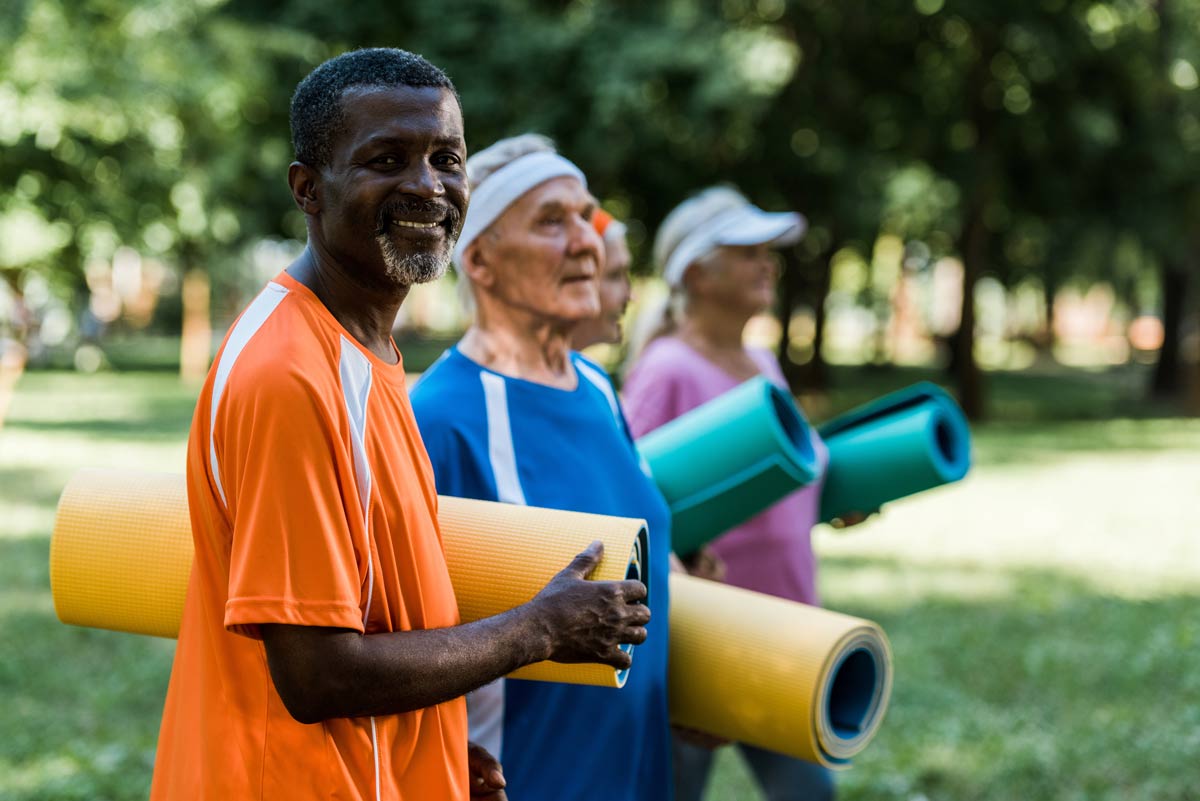 Proveer at Northgate | Group of active seniors holding yoga mats outdoors