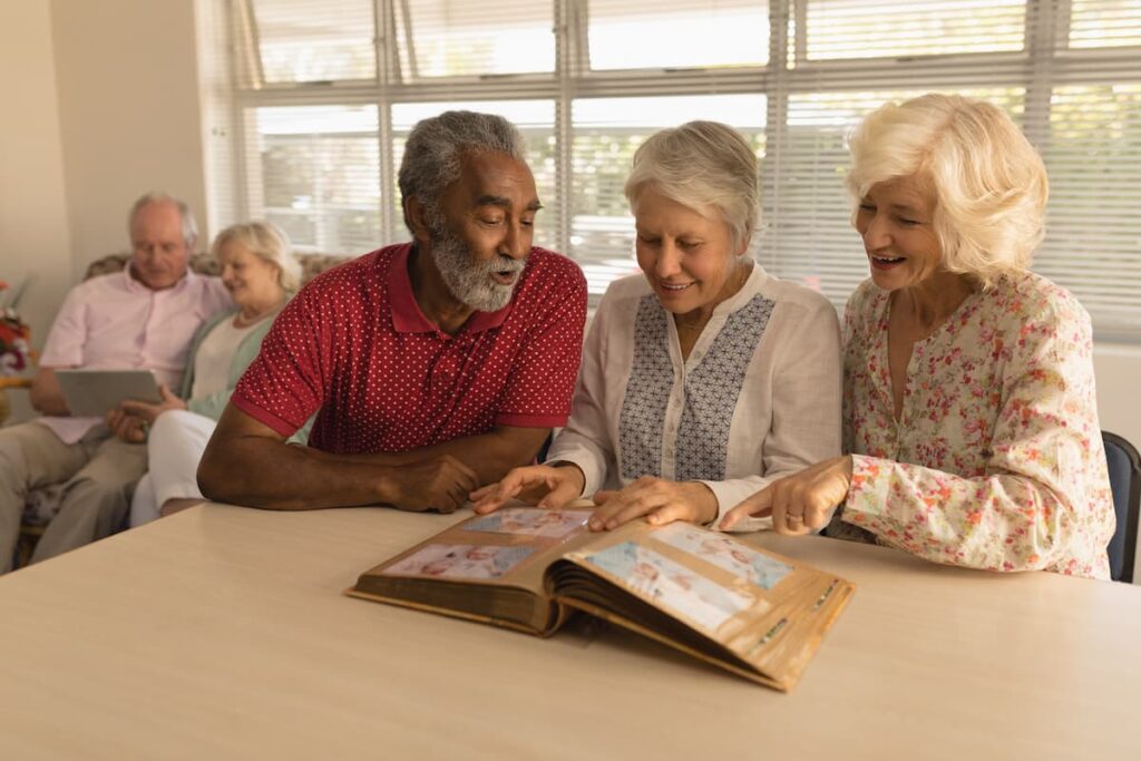 Proveer at Northgate | Group of seniors looking at photo album together - memory care Cypress, TX